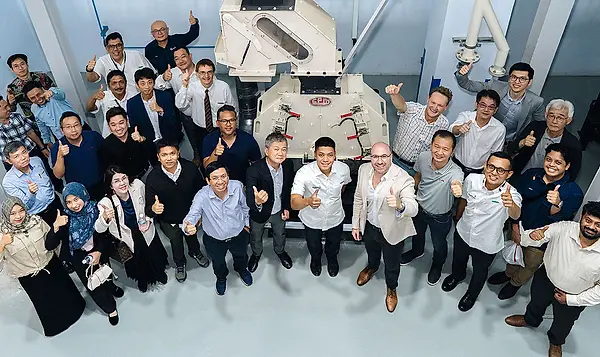 Large group of people smiling, with thumbs up, in the CPM Singapore test lab